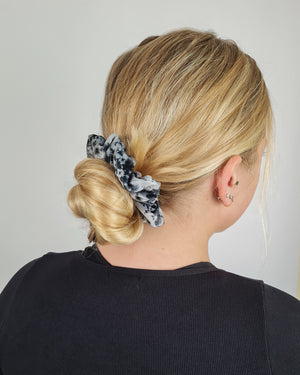 Charcoal tie dye velvet scrunchie shown in bun hairstyle