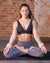 Girl in lotus yoga pose wearing neural coloured 1lb Heyflexi body bangles at a yoga studio